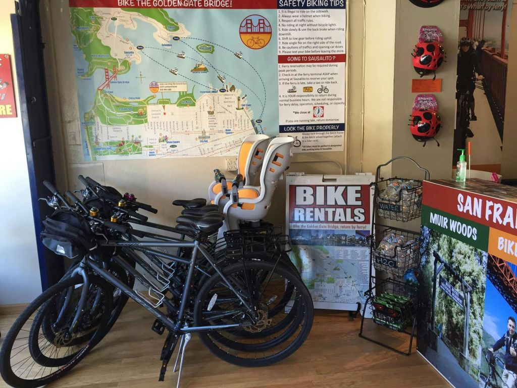 자전거 대여소에는 자전거, 유아용 카시트, 지도, 안전 팁, 뮤어 우즈 홍보 자료가 전시되어 있습니다.