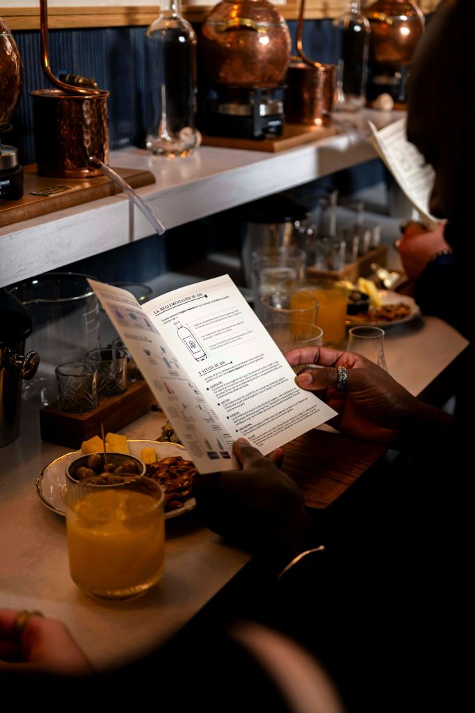 사람이 카운터에서 음료, 간식, 식기가 담긴 메뉴나 설명서를 조명이 희미한 곳에서 읽습니다.