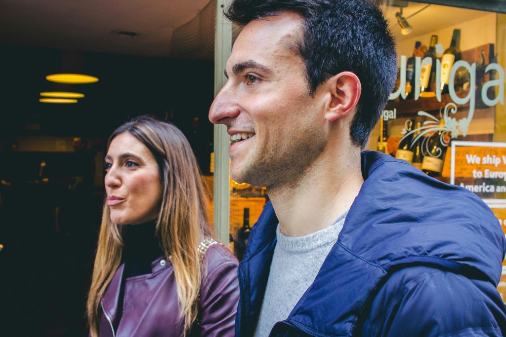 따뜻한 조명을 배경으로 실내에서 함께 서서 미소를 짓는 남성과 여성.