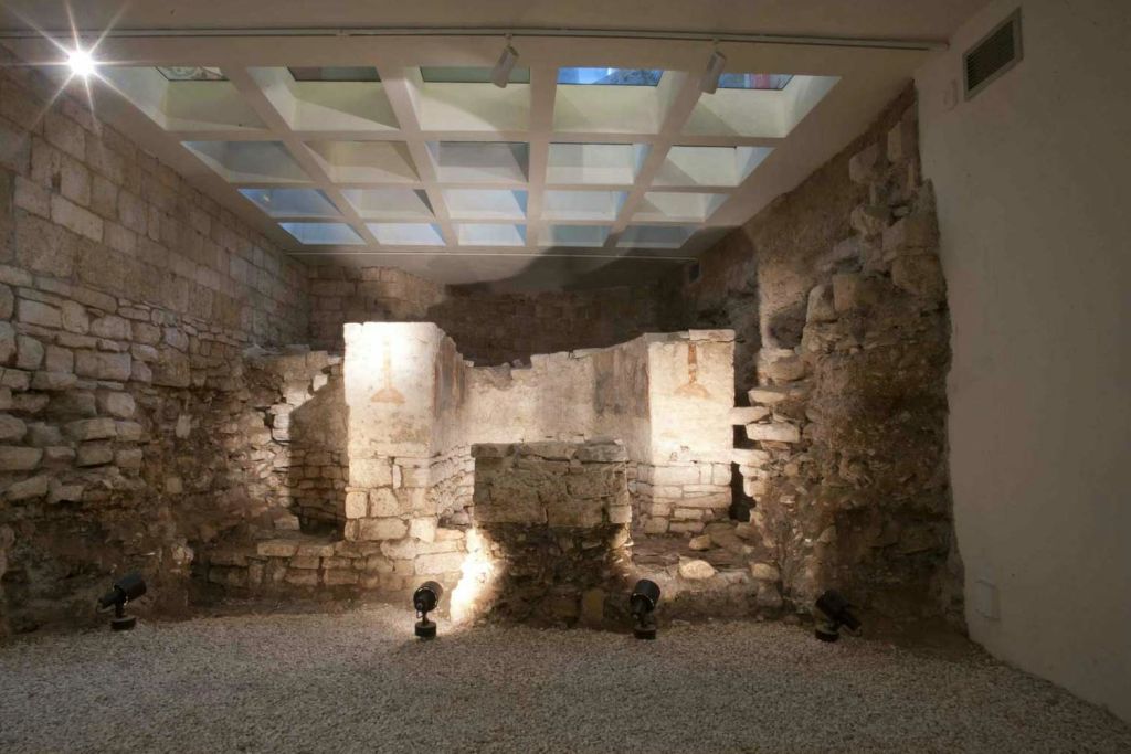 고대 석조 유적은 박물관과 같은 분위기의 유리 채광창 아래에서 스포트라이트로 조명을 받습니다.