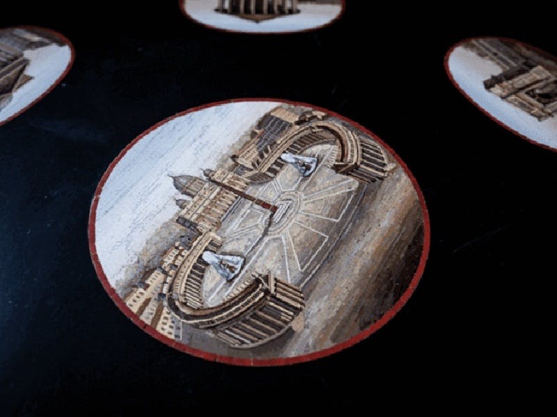 높은 각도에서 바라본 기둥, 건물, 동상이 있는 대형 광장의 상세한 그림을 묘사한 원형 이미지.