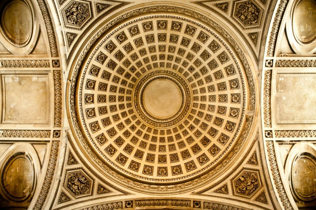 섬세한 건축 디자인과 경계를 이루는 정사각형과 원형 패턴의 화려한 돔형 천장.