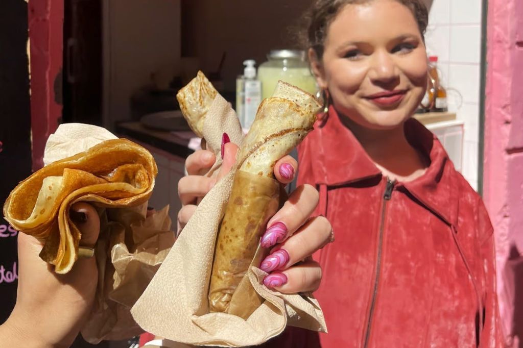 전경에 세 마리의 크레페와 빨간 재킷을 배경으로 한 여성이 옷을 입고 있습니다.