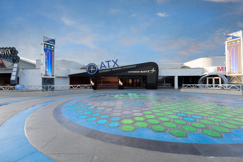 기하학적 패턴의 산책로와 맑고 푸른 하늘이 특징인 록히드 마틴의 "우주 비행사 훈련 체험" 입장권.