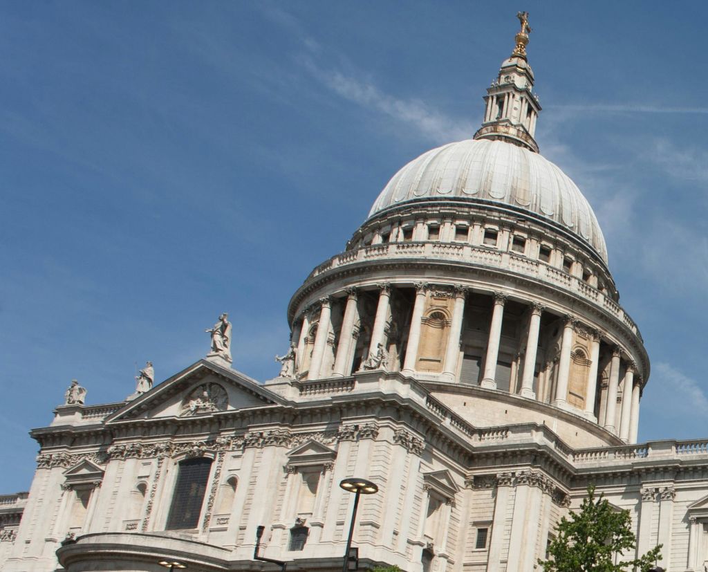 맑고 푸른 하늘 아래 기둥과 정교한 석조 디테일이 있는 크고 유서 깊은 돔형 건물입니다.
