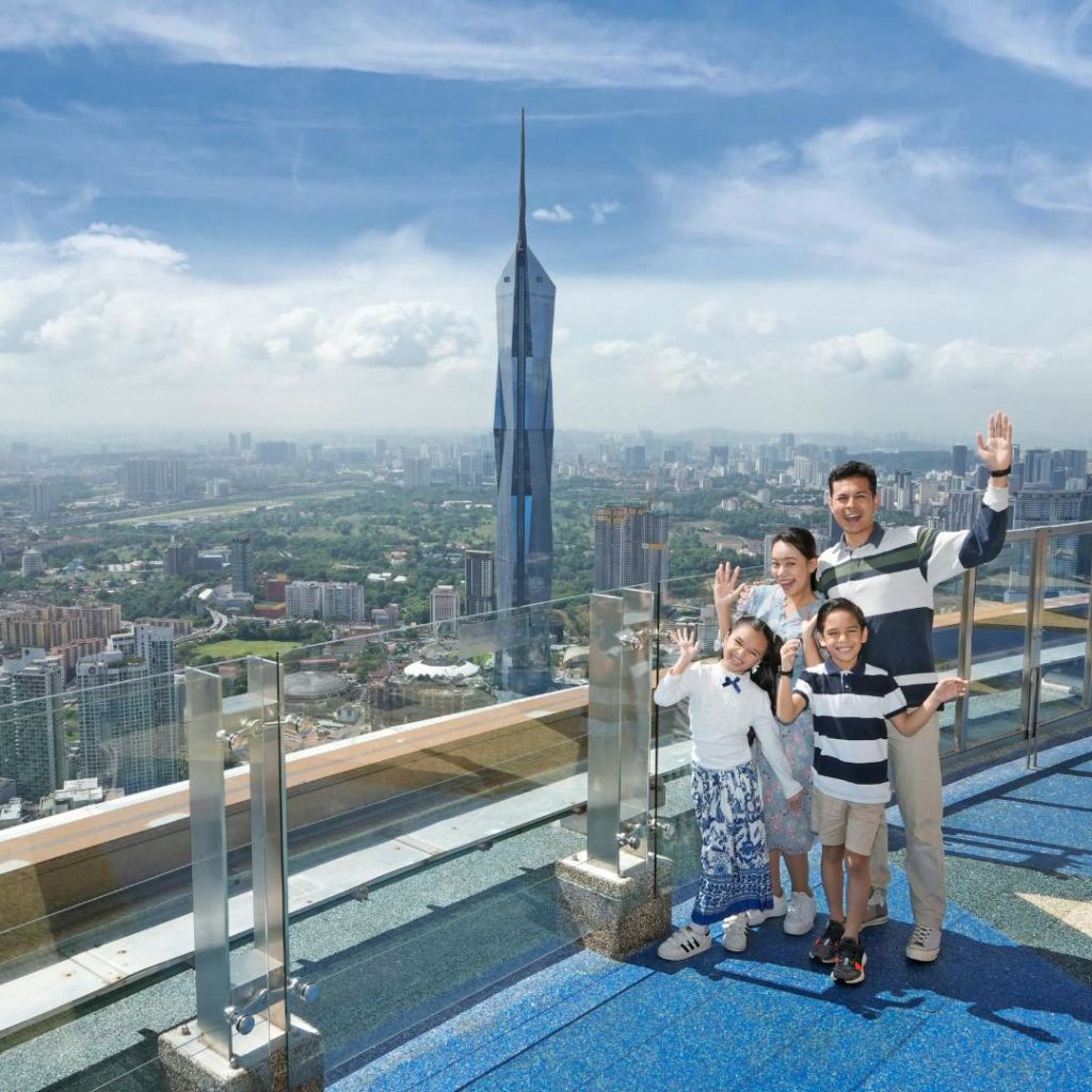 도시 풍경을 배경으로 높고 뾰족한 고층빌딩이 있는 전망대에서 내려다보이는 4인 가족의 파도입니다.