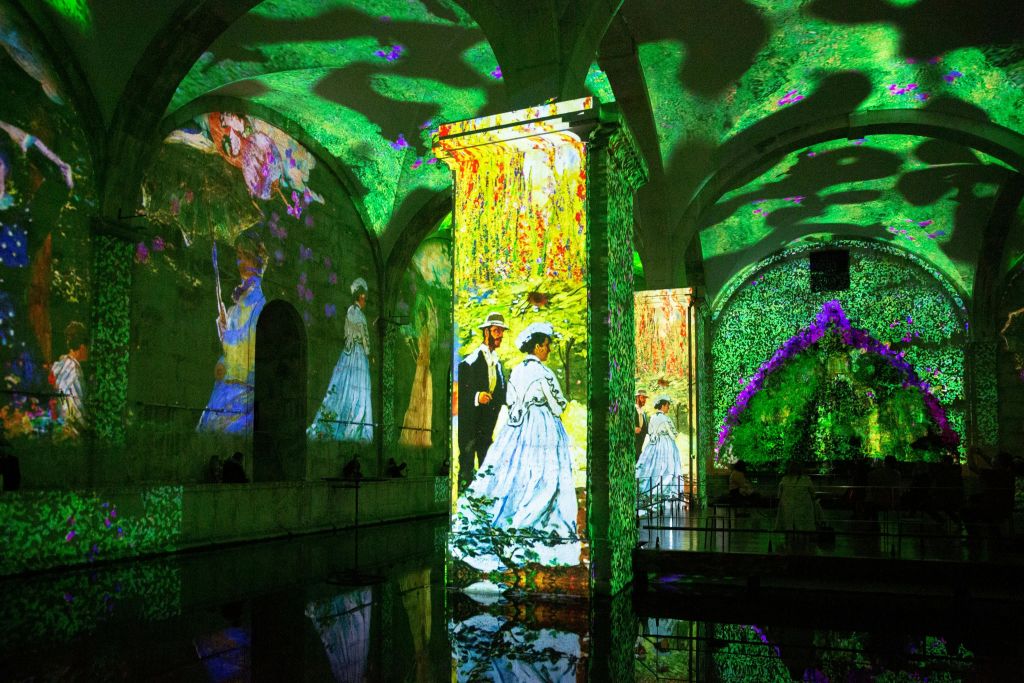 벽과 기둥에 사람, 꽃, 자연을 형형색색의 인상파 예술 작품이 전시된 아치형 객실로, 반짝이는 바닥에 반사됩니다.