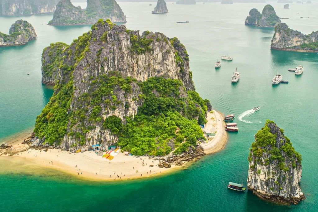 푸른 녹음이 우거진 작은 섬, 모래 해변, 주변 청록색 바다의 여러 보트의 공중 전망.