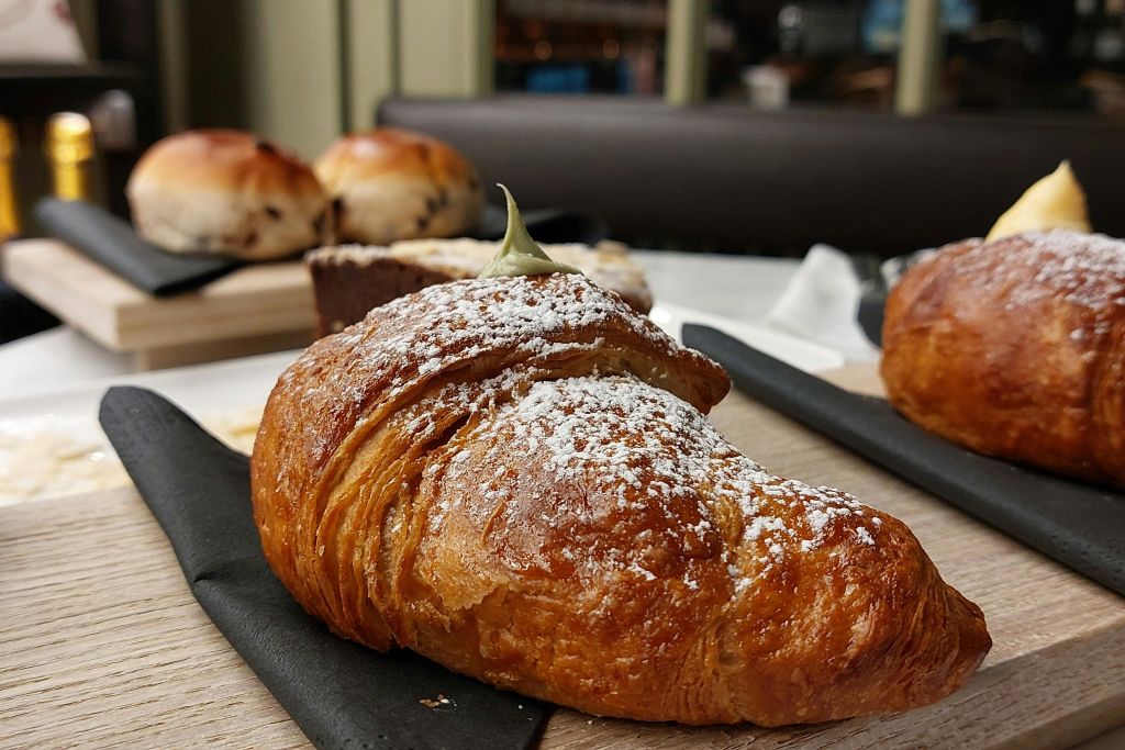 설탕 가루가 묻은 크루아상과 다른 페이스트리를 배경으로 한 클로즈업.