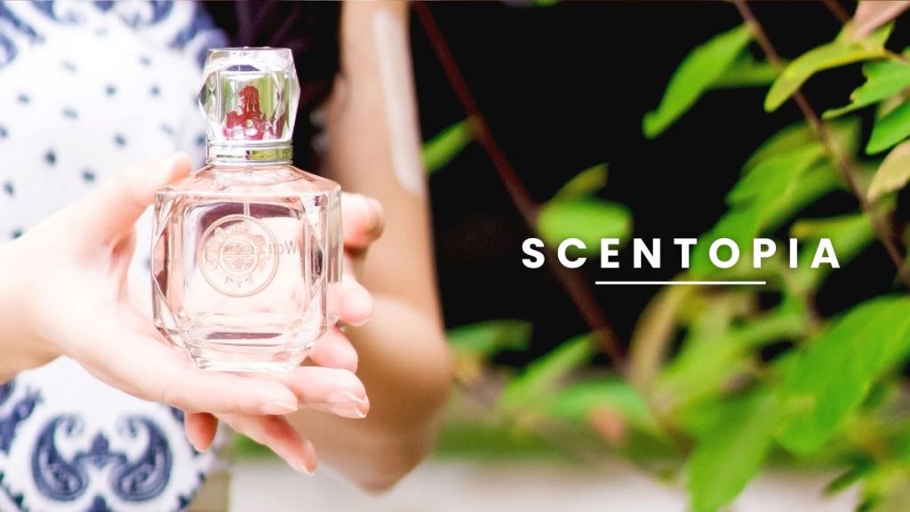 "향기" 라는 단어가 오른쪽에 표시된 야외에서 향수병을 들고 있는 사람의 클로즈업.