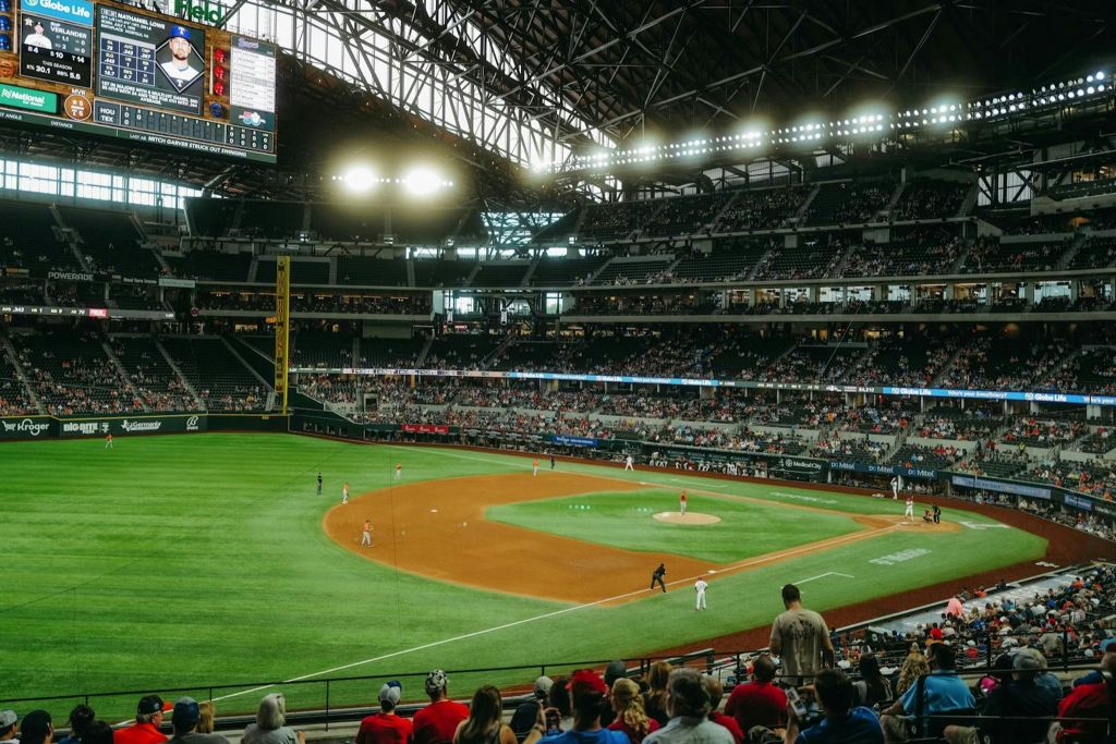스탠드에 관중이 있고 필드에 선수들이 있는 대형 경기장에서 진행 중인 야구 경기.