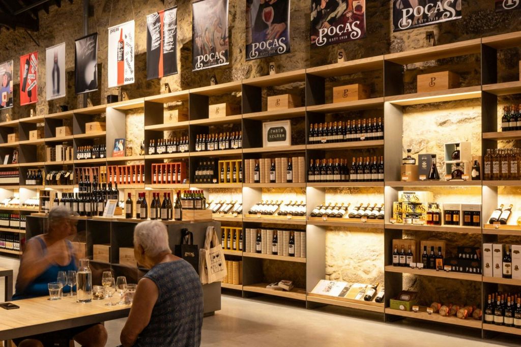 병과 상품을 진열할 수 있는 선반이 있는 와인 숍 인테리어. 앞에 앉은 사람이 보입니다.