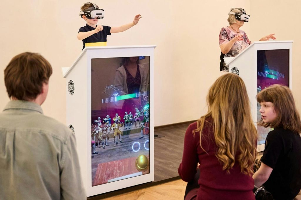 가상 현실 디스플레이와 상호 작용하는 사람들, VR 헤드셋을 착용한 두 사람, 대화형 화면을 관찰하는 두 사람.