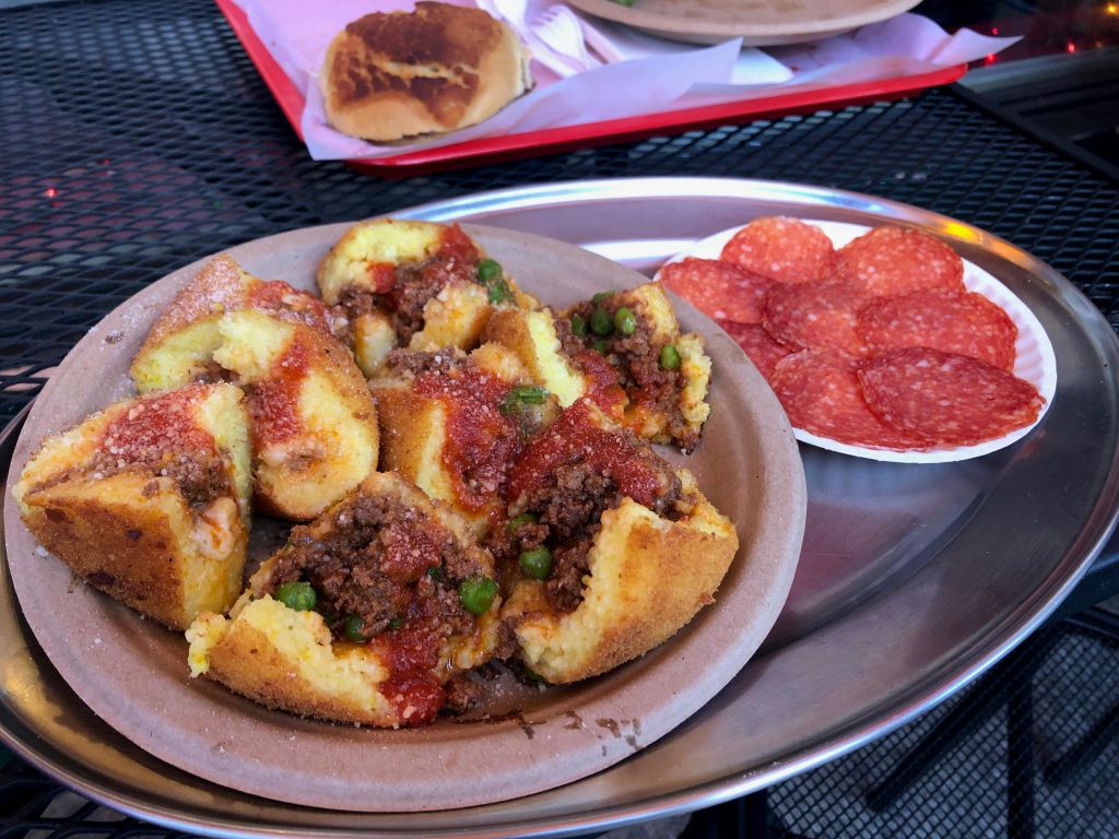 고기와 완두콩이 들어간 박제 폴렌타 접시에 토마토 소스를 곁들였습니다. 같은 트레이에 얇게 썬 페퍼로니의 반찬.