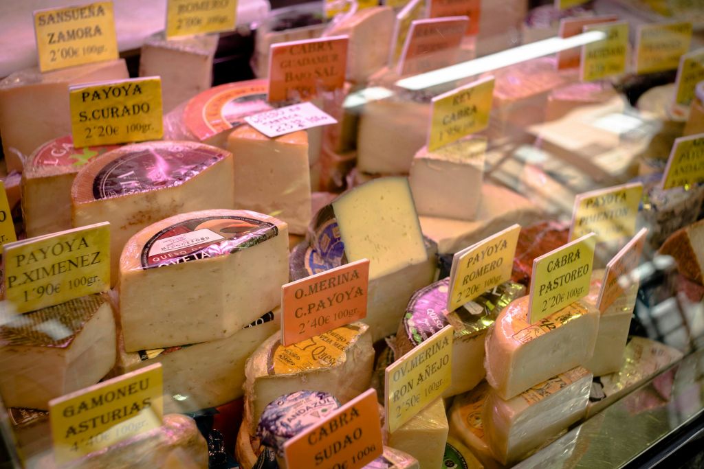 디스플레이 케이스에 다양한 라벨이 있는 다양한 휠과 치즈 웨지.