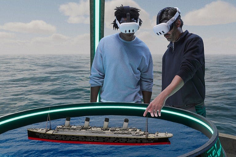 VR 헤드셋을 착용한 두 사람이 바다 위의 가상 환경에 떠 있는 선박의 3D 모델과 상호 작용합니다.