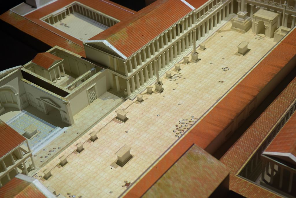 콜로네이드, 빨간색 타일 지붕, 열린 중앙 공간이 있는 고대 로마식 안뜰의 모델입니다.