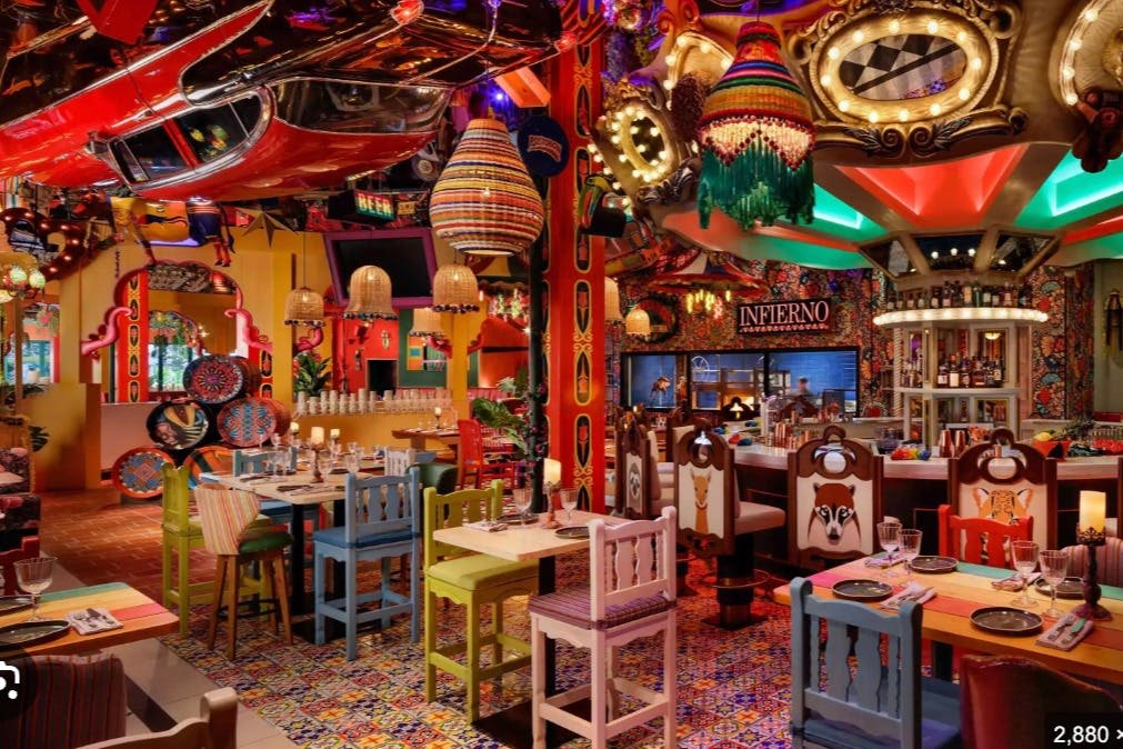 화려한 장식, 무늬 타일, 다양한 색상의 의자, 장난기 넘치는 동물 디자인이 돋보이는 활기차고 다채로운 레스토랑입니다.