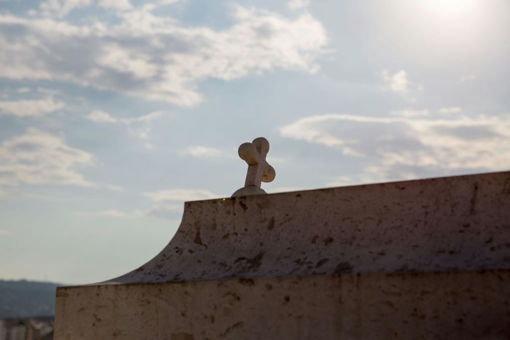 흐린 하늘과 밝은 햇빛을 배경으로 풍화된 구조물 위를 가로지르는 돌.