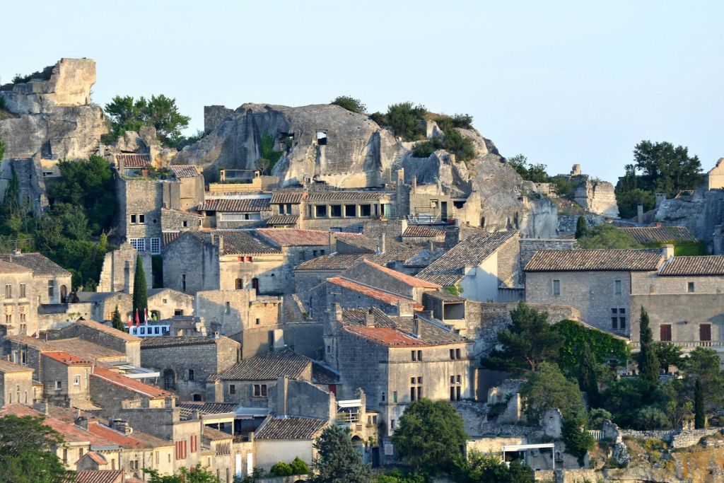 바위 절벽을 배경으로 녹음이 우거진 언덕에 중세의 석조 건물이 밀집해 있습니다.