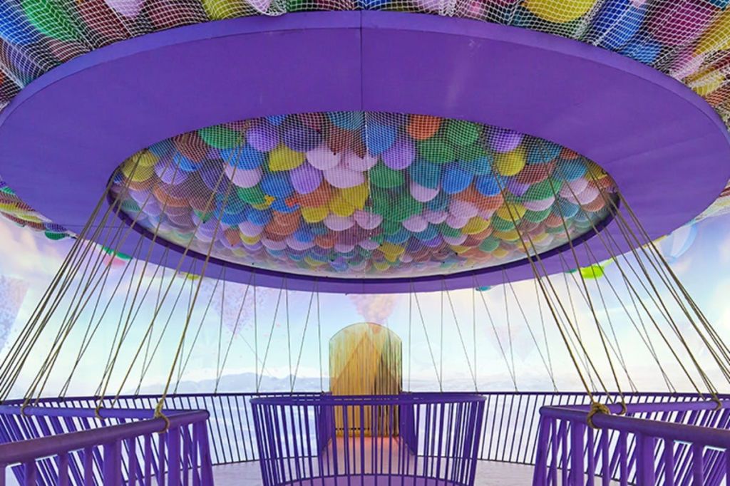 알록달록한 풍선이 그려진 보라색 천장, 하늘색 벽, 바깥으로 이어지는 출입구가 있는 방.