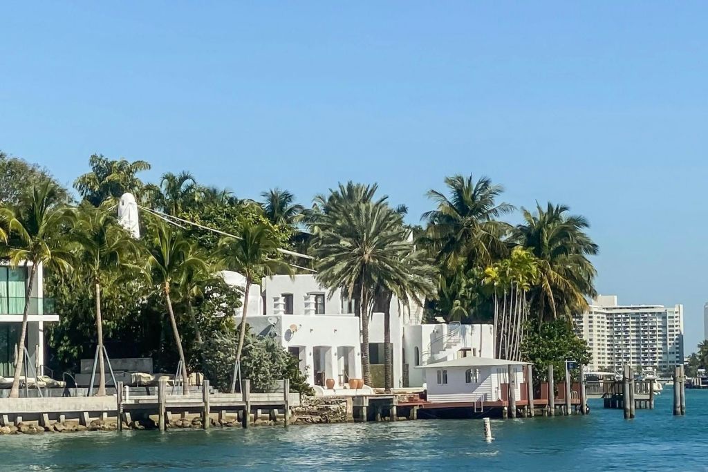 백악관은 야자수로 둘러싸여 있으며, 선착장이 있는 바닷가에 위치해 있습니다. 위쪽의 맑고 푸른 하늘.