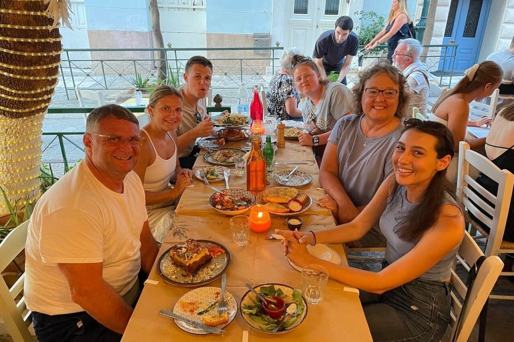 투어 가이드가 그리스 전통 선술집에서 저녁 식사를 하고 있습니다.