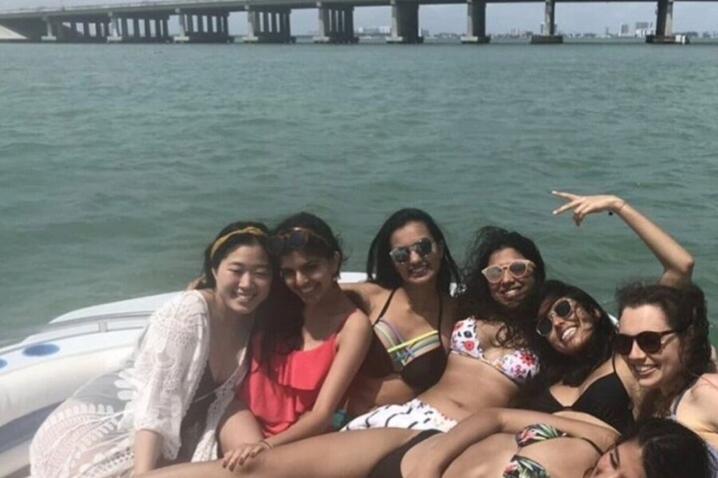 그룹은 배의 가장자리에 모였습니다. 공유된 순간과 탁 트인 바다에 대한 무한한 동지애의 스냅샷입니다.