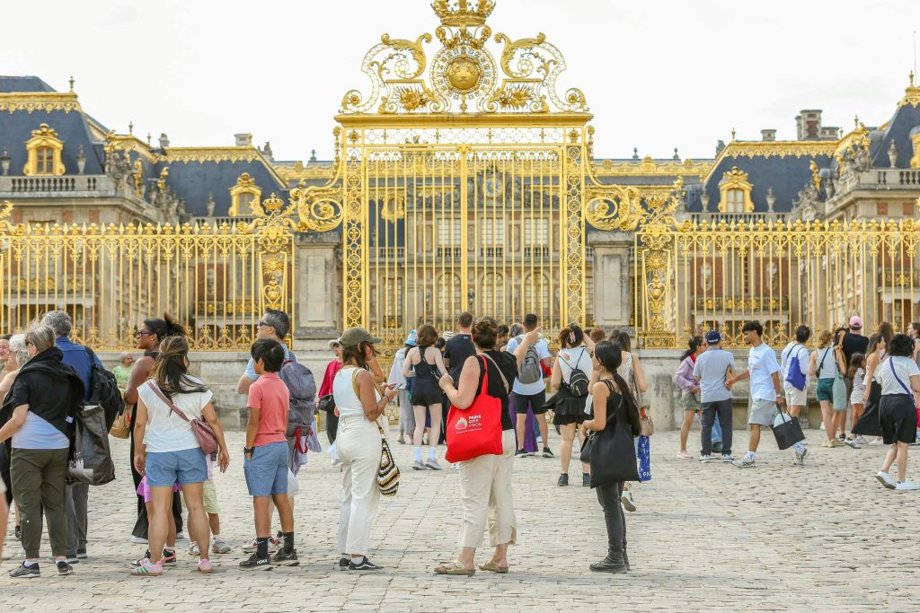 화려한 금문교 앞에 사람들이 모여듭니다. 저 너머로 역사적인 건물이 보입니다.