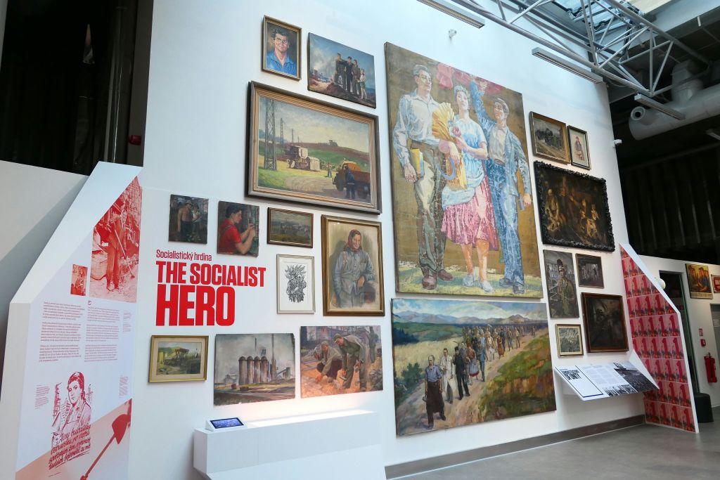 "사회주의 영웅" 이라는 라벨이 붙은 시골 환경과 산업 현장의 인물을 포함하여 여러 사회주의 테마의 그림을 전시하는 벽.