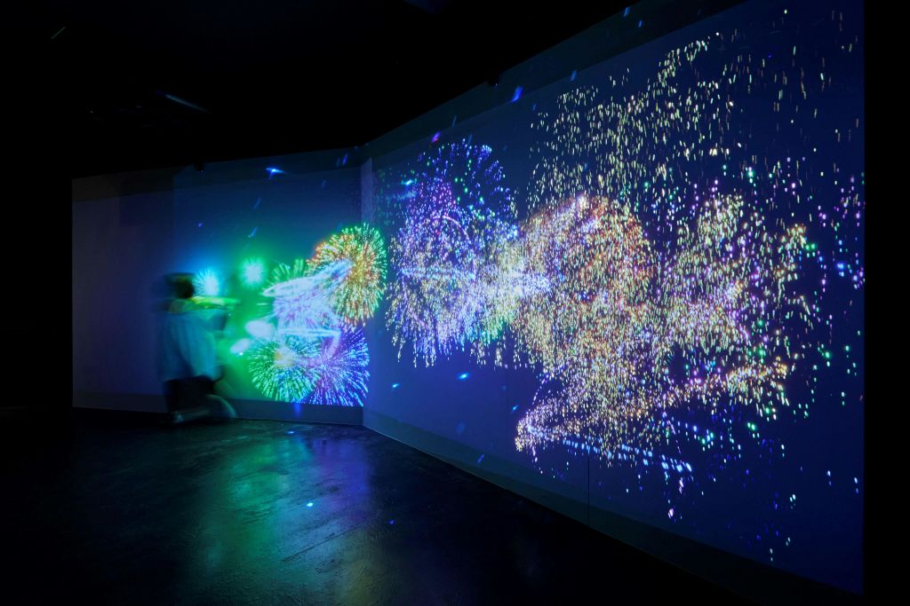 벽에 화려하고 빛나는 추상적인 조명 패턴이 투영된 어두운 방.