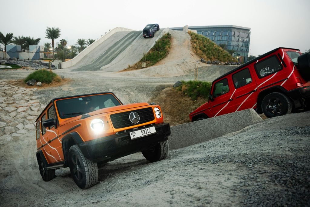 세 대의 메르세데스-벤츠 G-클래스 SUV가 언덕과 자갈이 있는 험준한 오프로드 코스를 항해합니다.