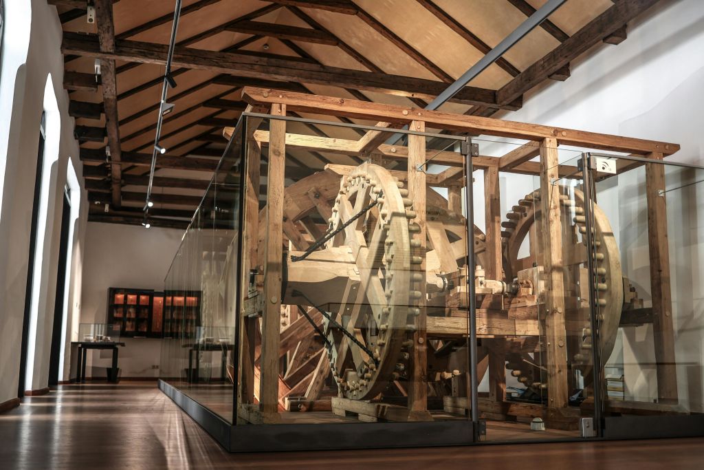 높은 목재 기둥 천장이 있는 박물관의 유리 뒤에 대형 목재 기계 구조물이 전시되어 있습니다.