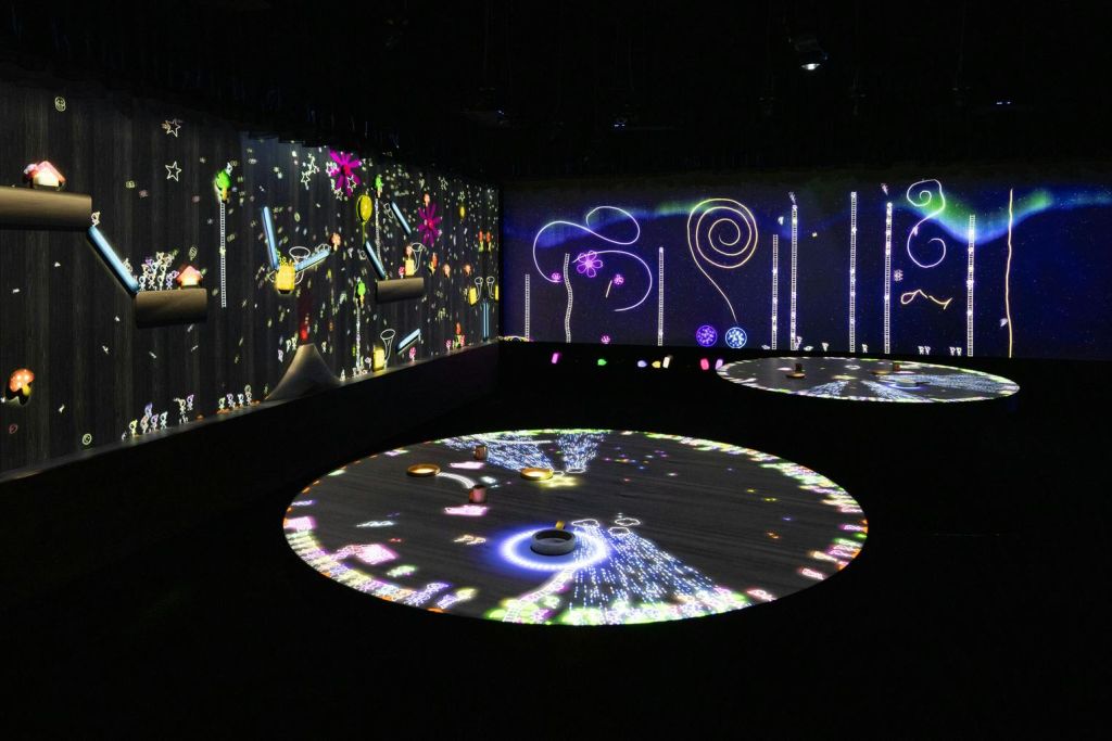 벽과 원형 테이블에 화려하고 추상적인 조명이 투영된 어두운 조명 공간입니다.