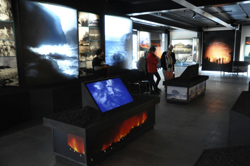 자연 경관의 조명 이미지, 인터랙티브 디스플레이, 디스플레이를 관찰하는 여러 사람이 있는 박물관 전시관입니다.