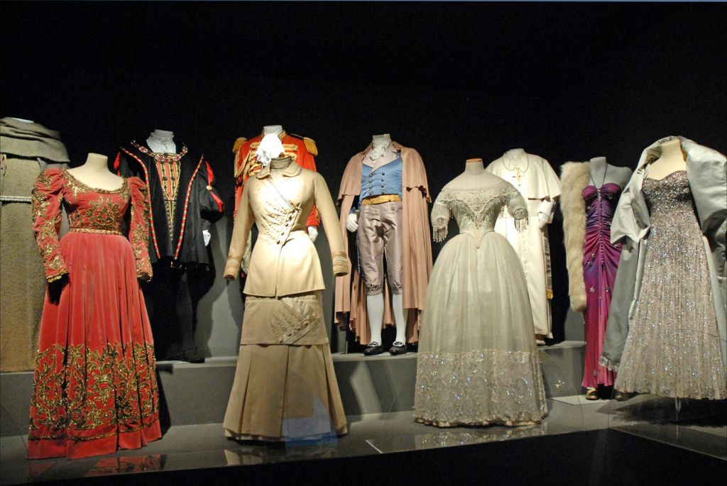드레스, 수트, 마네킹에 장식된 로브를 포함한 역사적이고 연극적인 의상이 전시되어 있습니다.