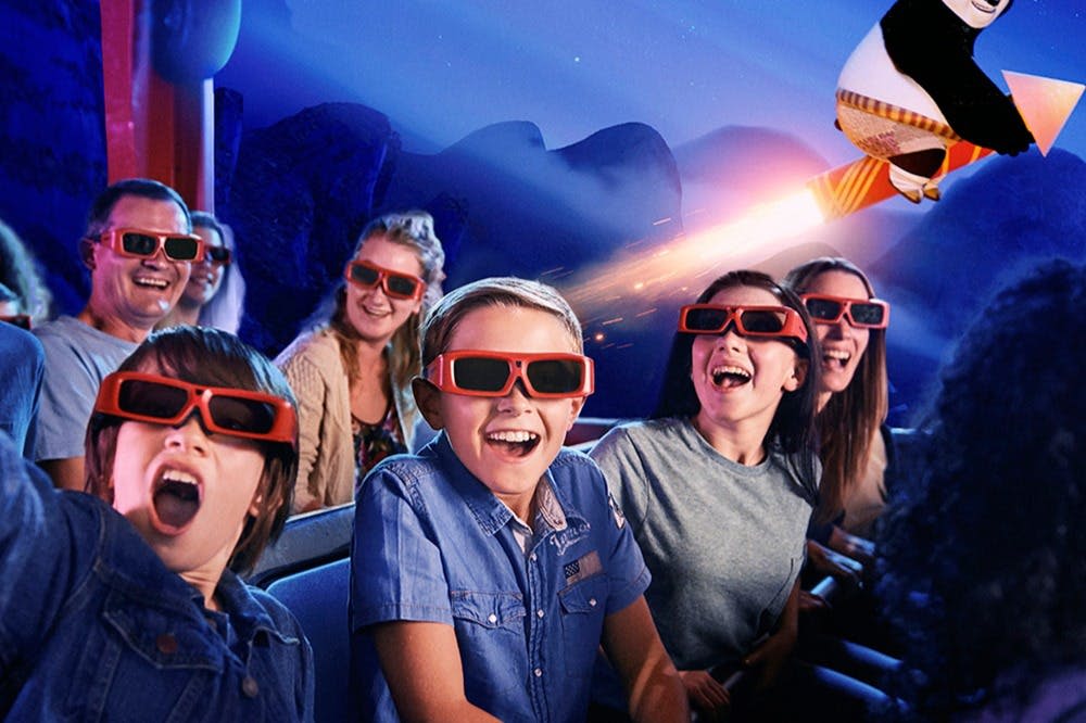 3D 안경을 쓰고 미소 짓고 웃으며 역동적이고 빛나는 배경을 배경으로 테마파크를 즐겨보세요.