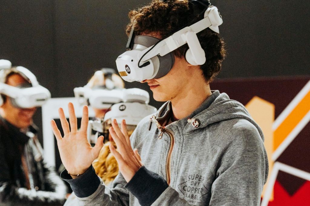 VR 헤드셋을 착용한 한 무리의 사람들이 가상 현실에 몰입한 채 손을 들고 있습니다.