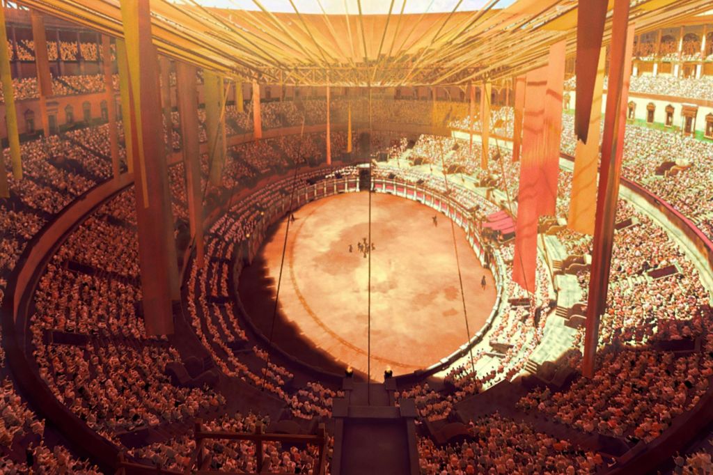 층층이 쌓인 좌석과 중앙 무대가 있는 크고 붐비는 경기장은 현수막이 걸려 있는 지붕 아래에서 따뜻하게 불을 켰습니다.