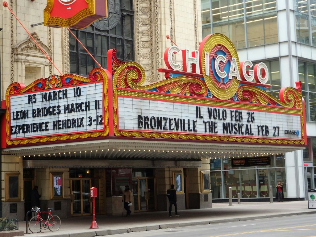 Il Volo, Bridges, Jimi Hendrix 경의를 표하는 등 예정된 이벤트를 보여주는 시카고 극장 마키. 도로와 출입구가 보입니다.