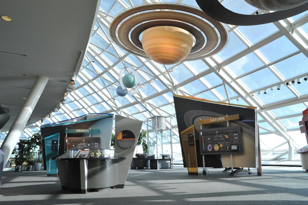 천왕성과 토성 모델을 이용한 과학 전시회. 디스플레이와 정보 패널은 커다란 유리 천장 아래에 있습니다.