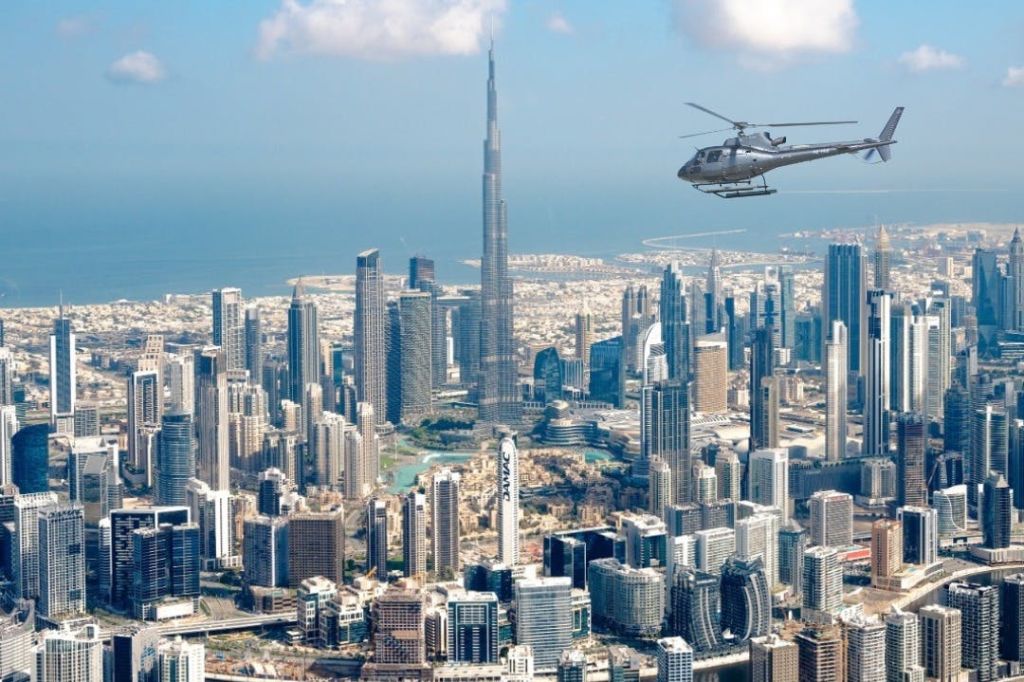 부르즈 할리파 (Burj Khalifa) 가 내려다보이는 비즈니스 베이 (Business Bay) 위를 맴도는 헬리두바이 (HeliDubai) 헬리콥터.