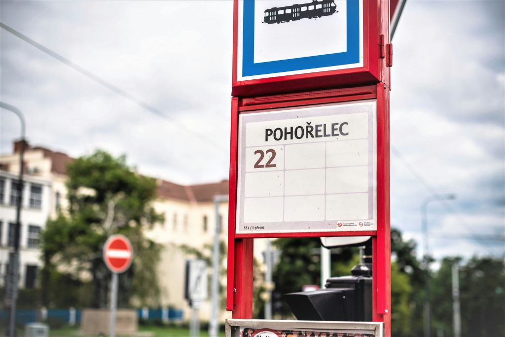 건물과 나무를 배경으로 '포호엘렉' 과 숫자 22가 표시된 빨간색 트램 정차 표지판이 있습니다.