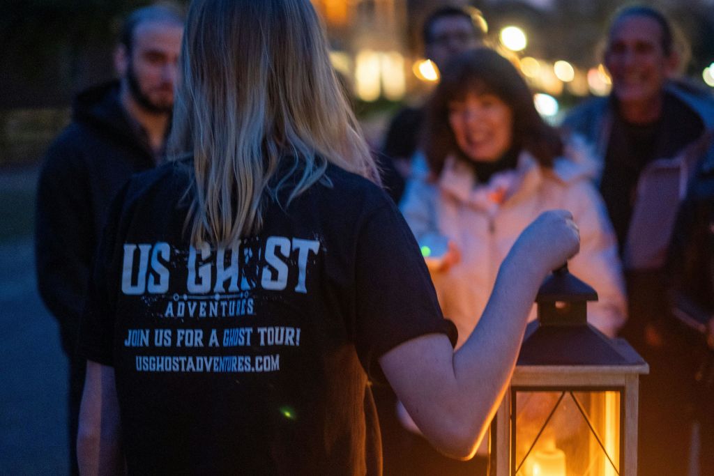 랜턴 라이트로 유령 이야기를 들려주는 투어 가이드