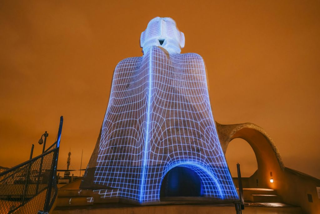 주황색 하늘에 파란색 격자 무늬가 있는 석조 조각은 아치형 개구부와 각도 모양이 특징입니다.