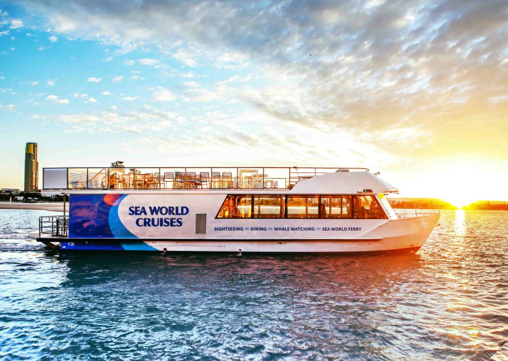 부분적으로 흐린 하늘 아래 석양에 "씨월드 크루즈" 라는 이름의 페리가 있습니다.