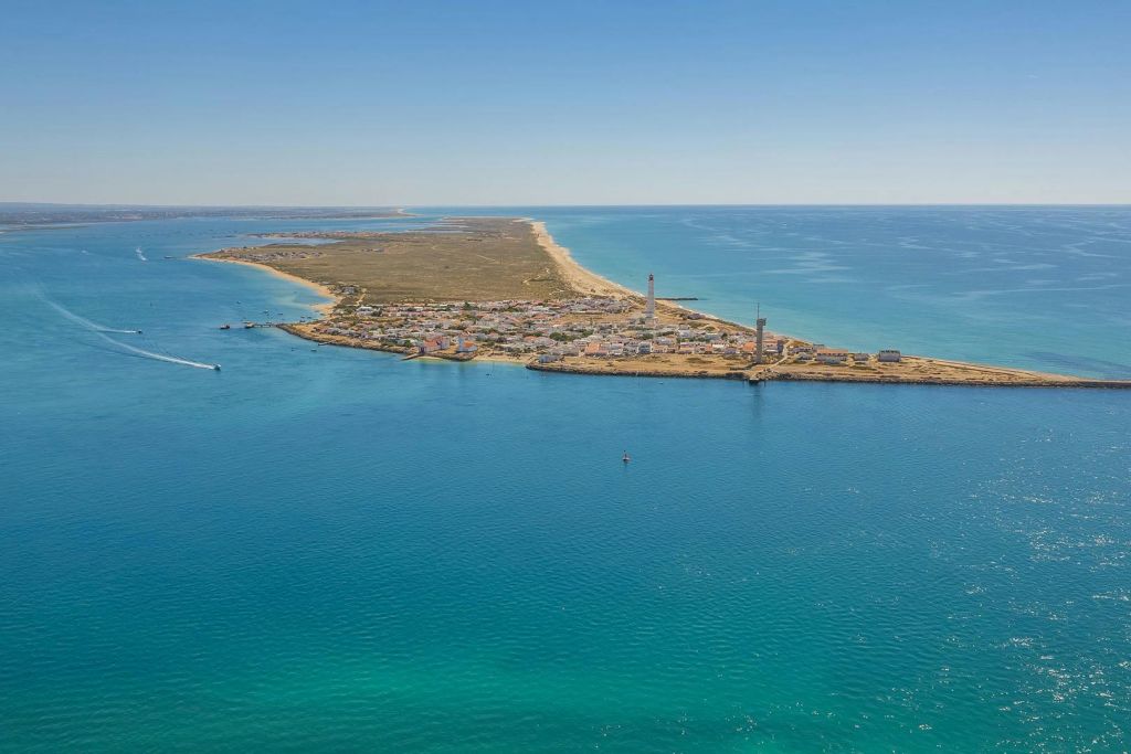 좁은 반도를 따라 펼쳐진 등대, 모래 해변, 블루오션이 있는 파롤 섬의 공중 전망.