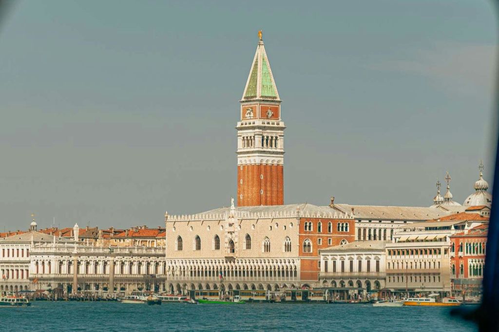 이탈리아 베네치아의 두칼레 궁전과 산 마르코 캄파닐레의 전경, 맑은 하늘 아래 전경이 펼쳐집니다.