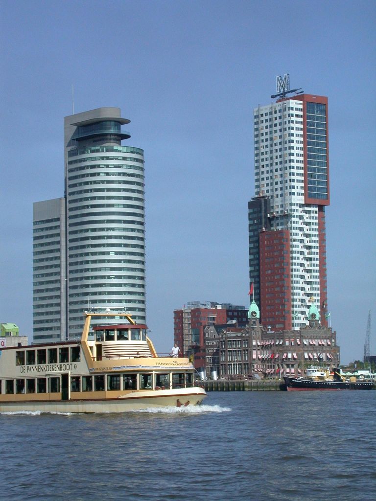 맑고 푸른 하늘을 배경으로 현대적인 고층 건물과 역사적인 건축물이 있는 강에서 페리 보트를 타보세요.