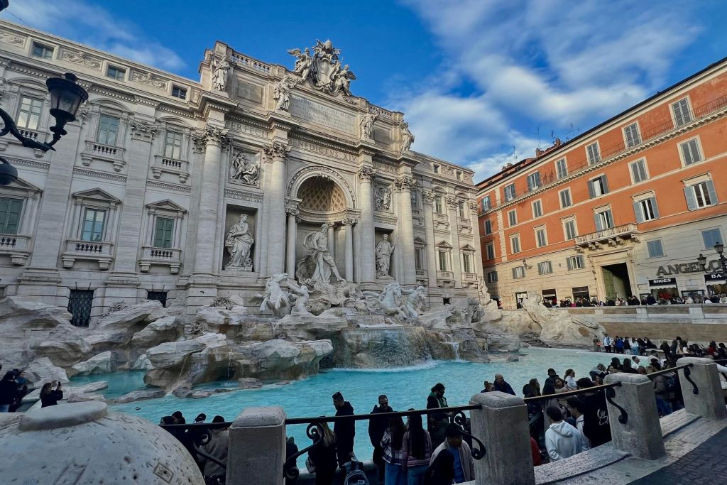이탈리아 로마의 트레비 분수 근처에는 화려한 조각상과 계단식 물이 푸른 하늘 아래 가득했습니다.